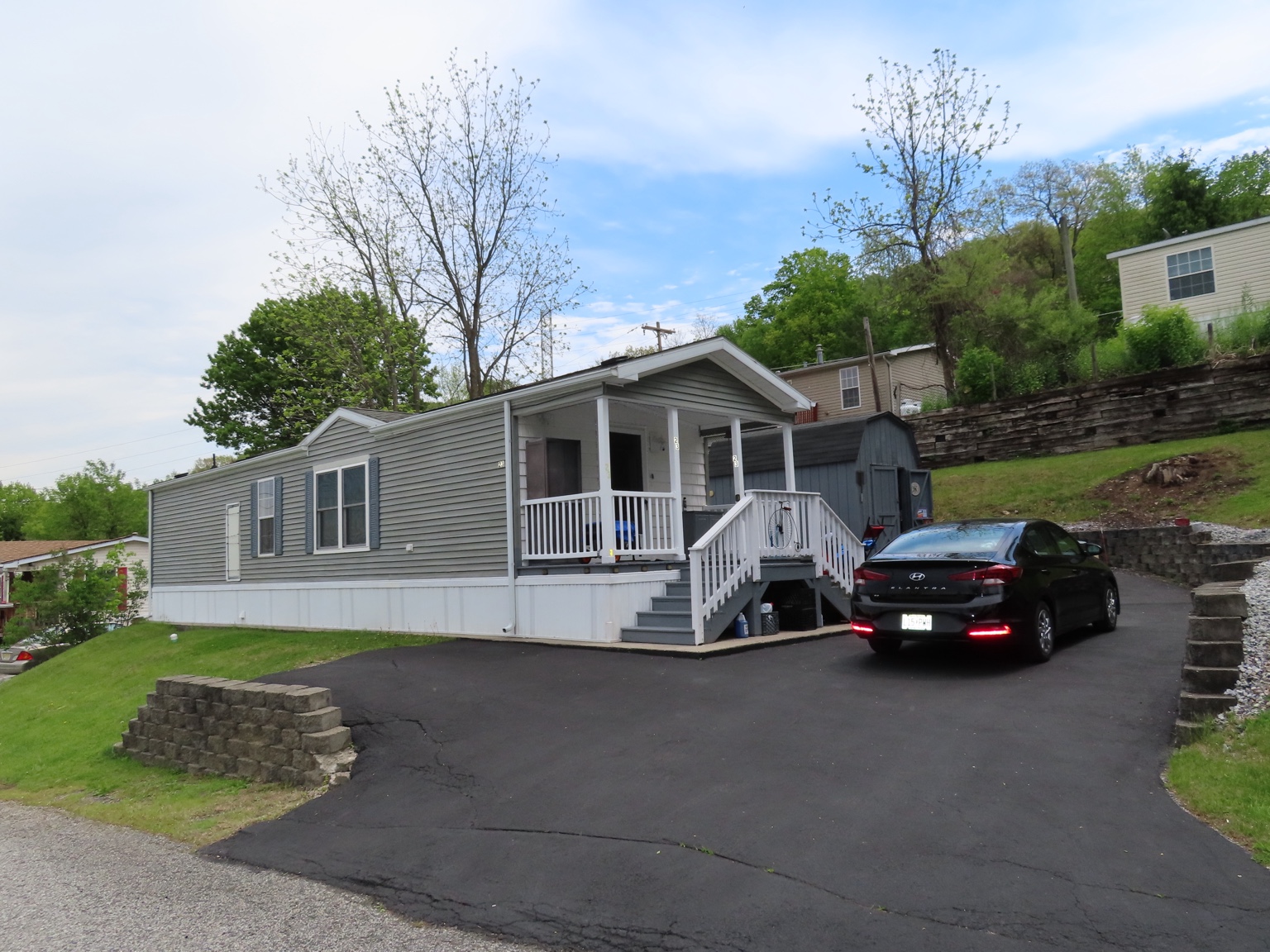 Manufactured home with gray driveway in Hillside Estates